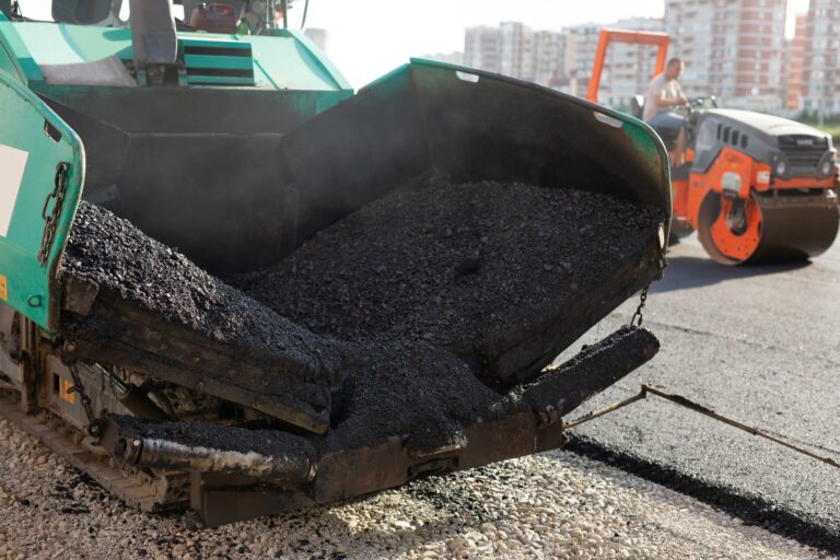 An asphalt spreader or an asphalt paver machine on a road construction site. Road repairs.