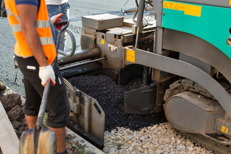 An asphalt spreader or an asphalt paver machine on a road construction site. Road repairs.