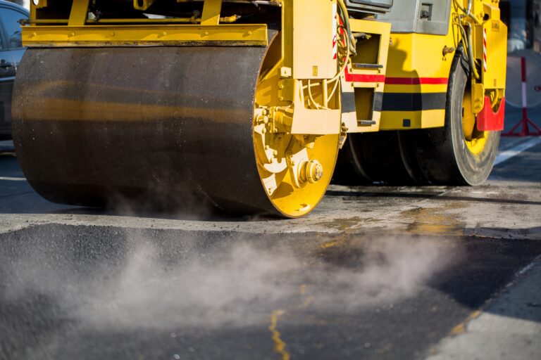 Compact steamroller flatten out the asphalt