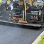 Detail of asphalt paver machine during road industrial pavement truck laying fresh asphalt on