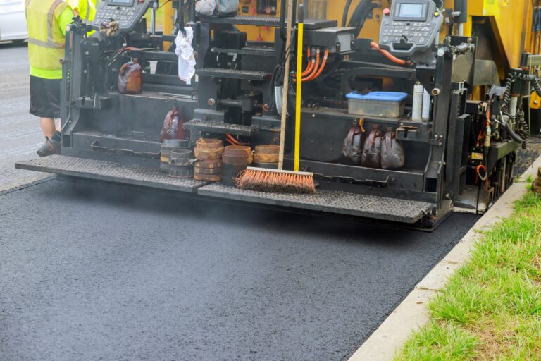 Detail of asphalt paver machine during road industrial pavement truck laying fresh asphalt on