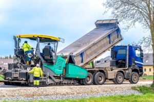 machine asphalting of roads. truck with asphalt. the creation of a new transport communication and