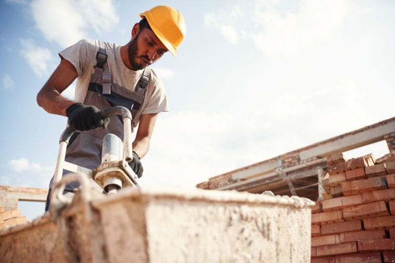 Mixes concrete. Handsome Indian man is on the construction site