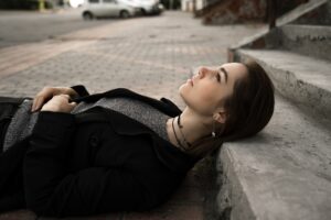 the girl lies on the concrete stairs, looks up