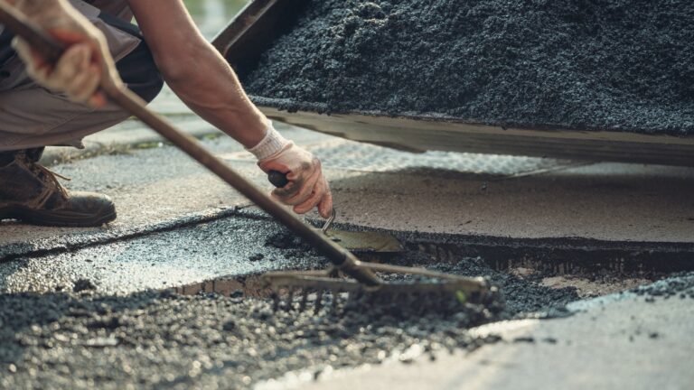 Two workers laying new asphalt