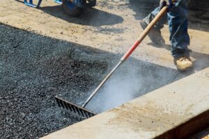 Workers on Asphalting paver during Road street repairing works