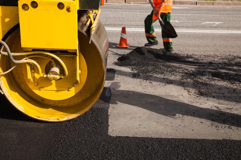 Pavement machine laying fresh asphalt or bitumen on top of the gravel