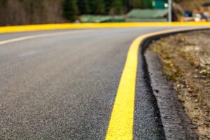 Perspective of asphalt road with yellow line on it