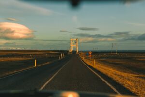 pov from car on asphalt road at sunset in iceland