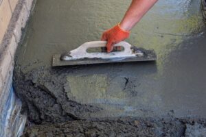 Builder smoothing the surface of screed