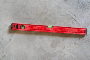 The construction technician is working by leveling the concrete floor to be smooth.